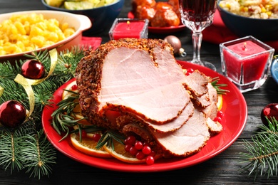 Photo of Plate with delicious ham served on dark wooden table. Christmas dinner