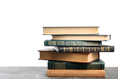 Stack of old vintage books on grey stone table against white background