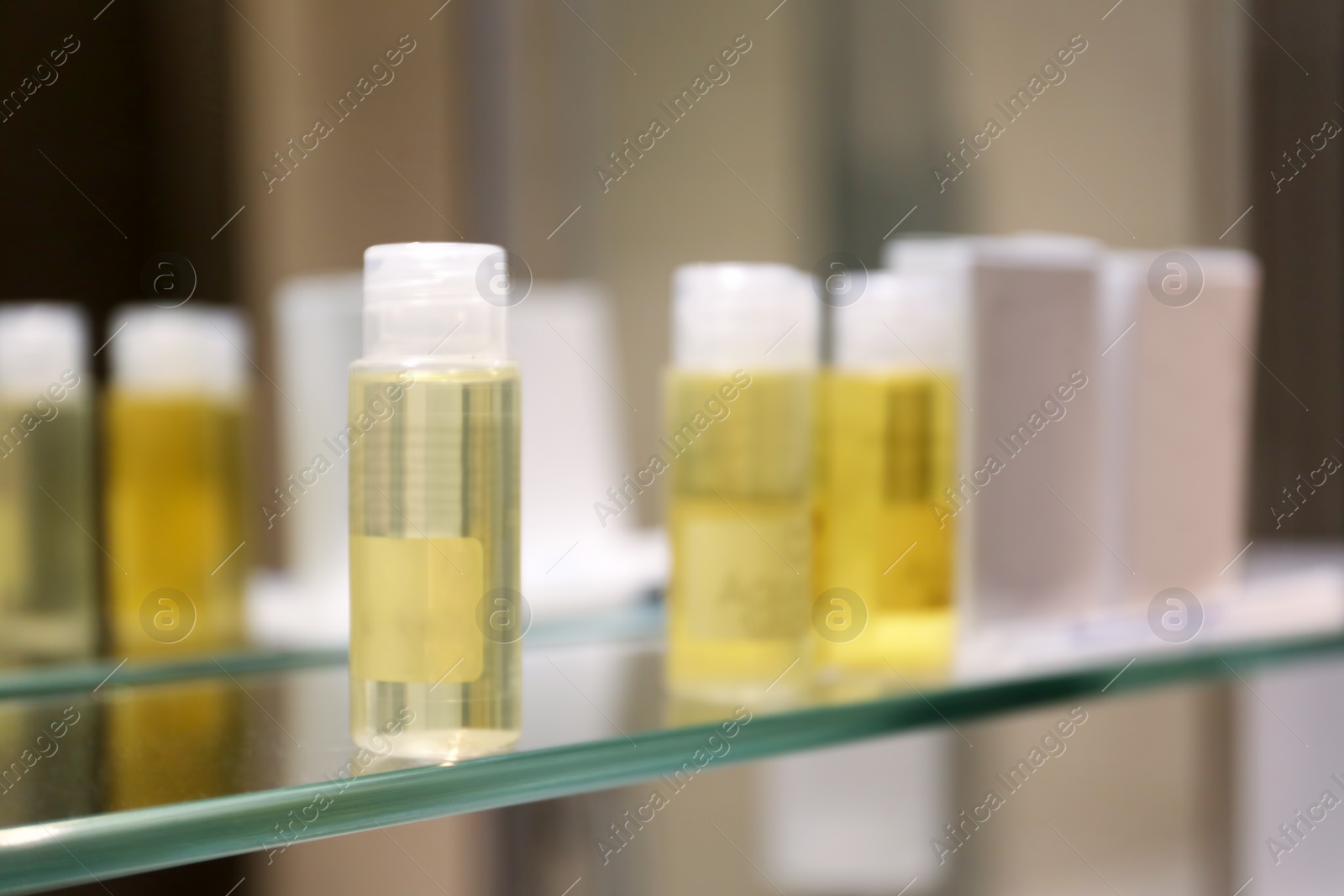 Photo of Hotel amenities on glass shelf near mirror in bathroom