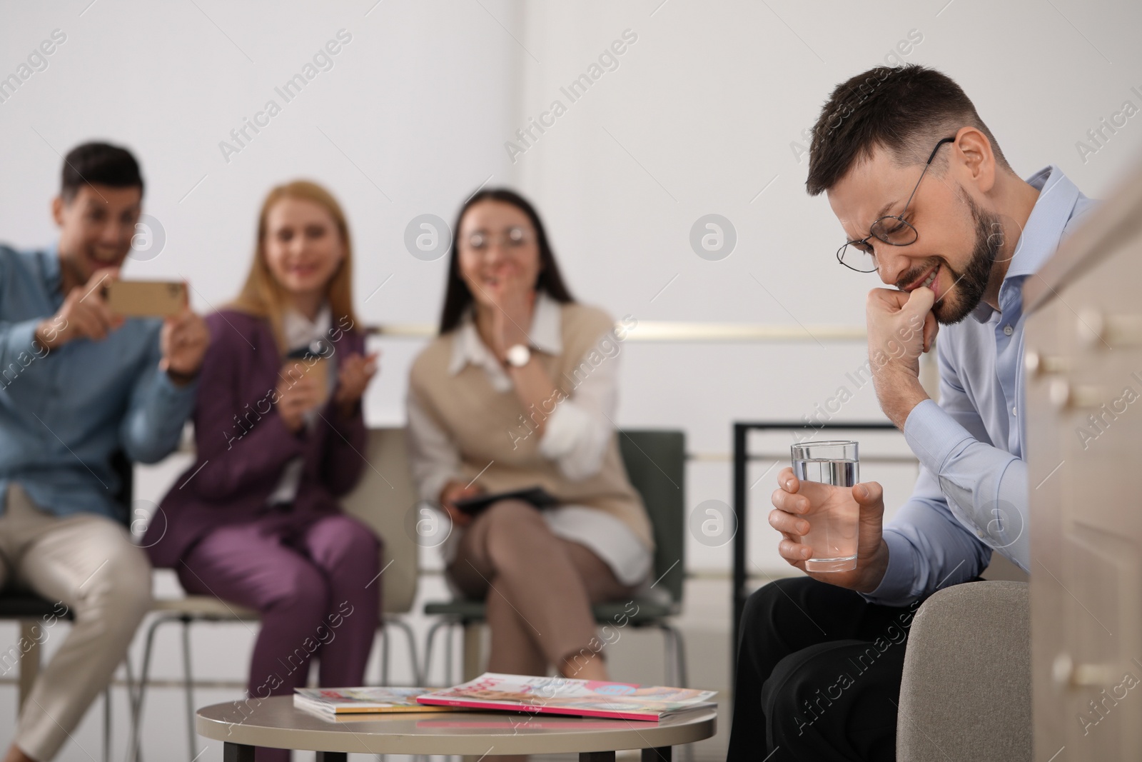 Photo of Coworkers bullying their colleague in office, space for text