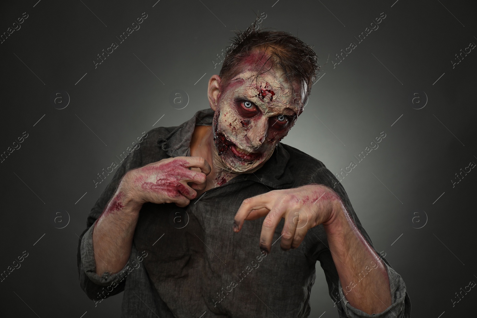 Photo of Scary zombie on dark background. Halloween monster