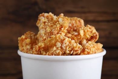 Photo of Bucket with yummy nuggets against blurred background, closeup