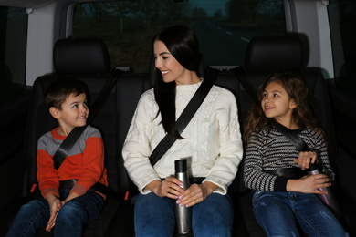 Mother with little children in modern car. Family trip