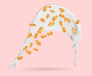 Image of Rolled oats and milk splash on pink background