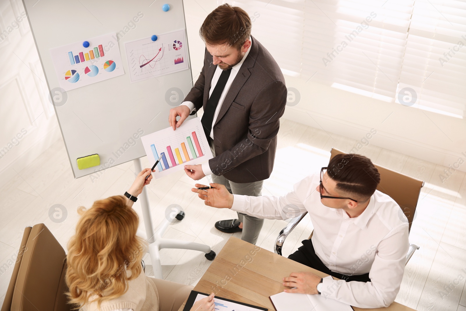 Photo of Businesspeople having meeting in office, above view. Management consulting