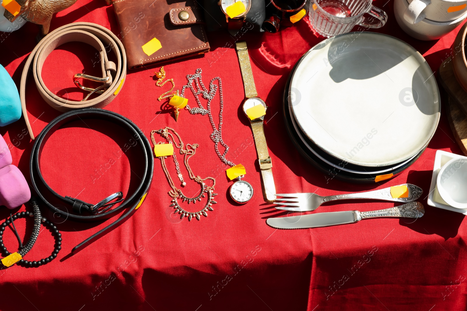 Photo of Many different items on table outdoors, above view. Garage sale