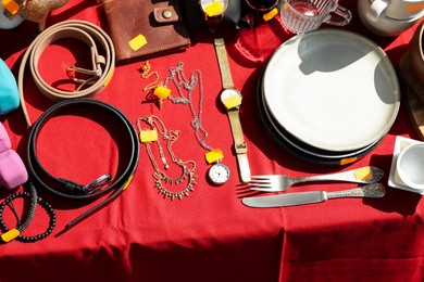 Many different items on table outdoors, above view. Garage sale