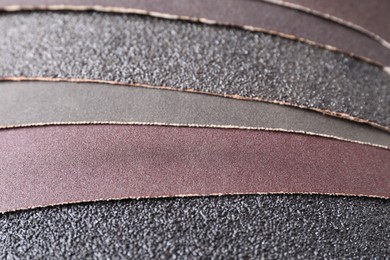 Photo of Many sheets of sandpaper as background, closeup