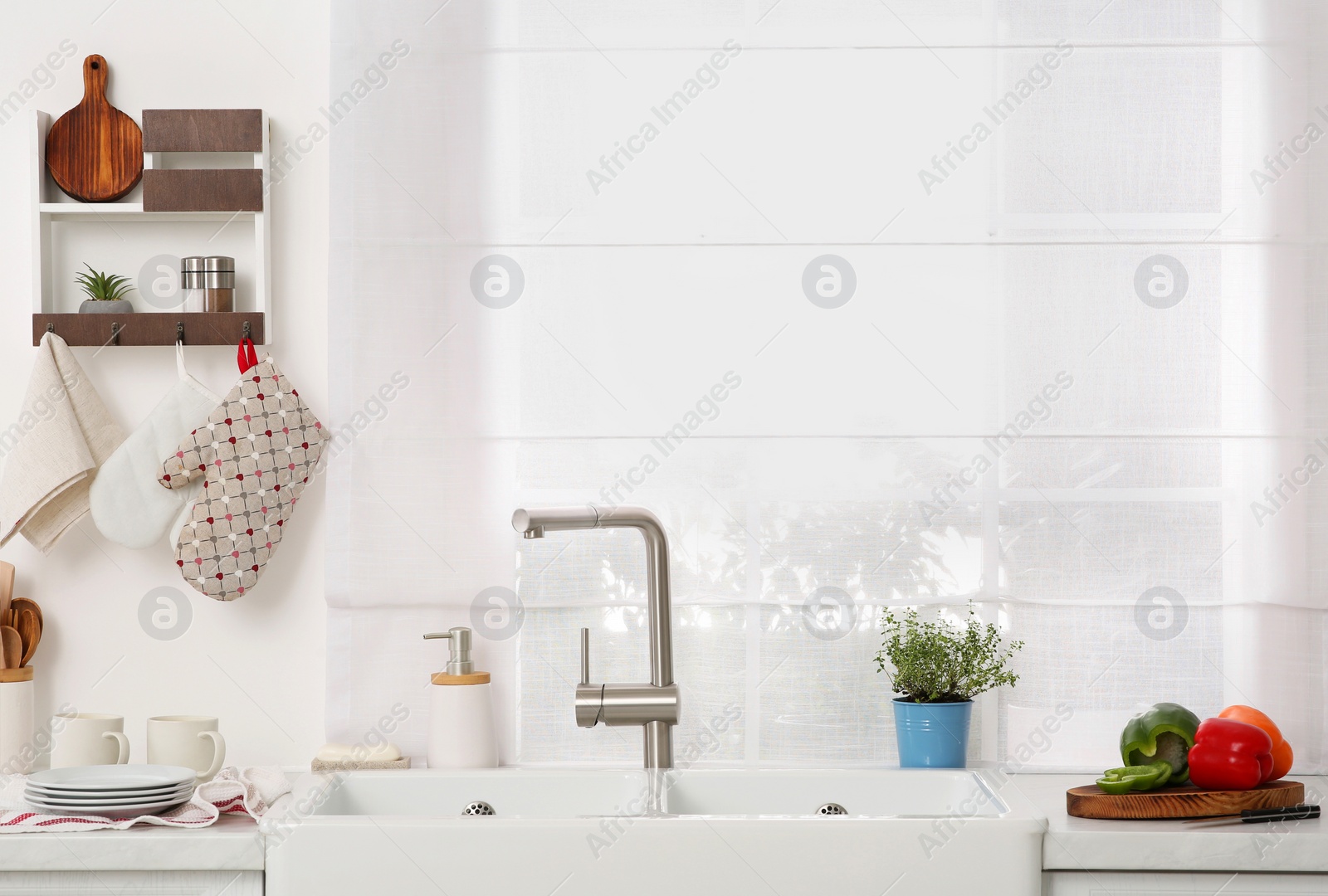 Photo of Kitchen counter with sinks, utensils and vegetables