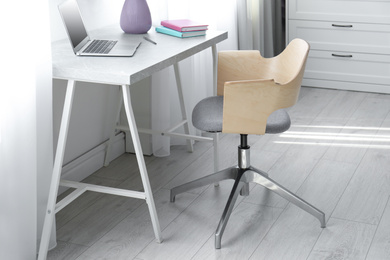 Photo of Comfortable workplace with office chair and modern table