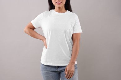 Photo of Woman wearing white t-shirt on light grey background, closeup