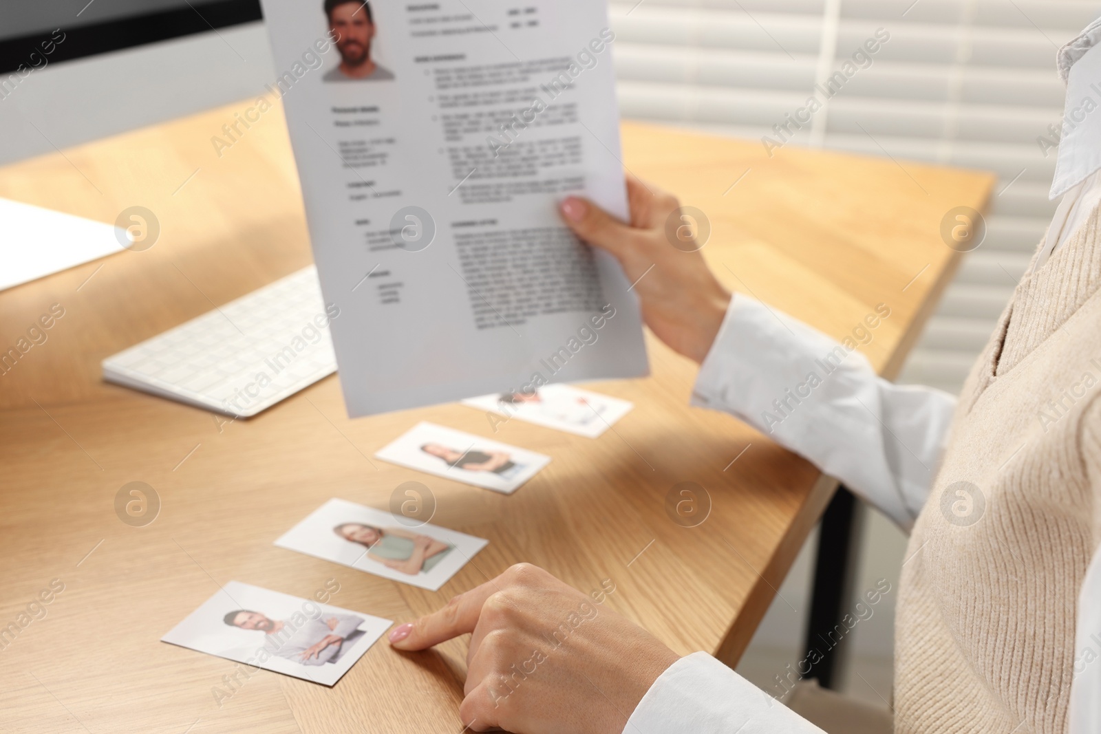 Photo of Human resources manager reading applicant's resume in office, closeup