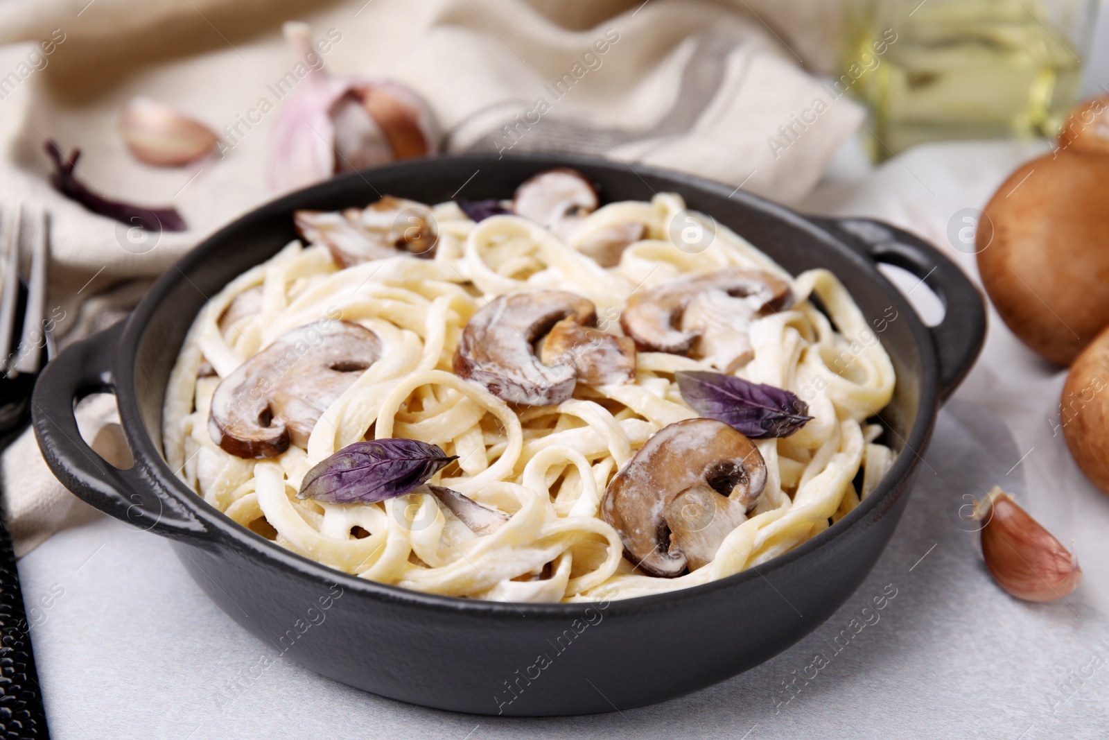 Photo of Delicious pasta with mushrooms on grey table, closeup