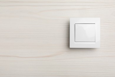 Photo of Modern light switch on white background. Space for text