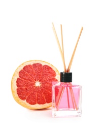 Aromatic reed air freshener and grapefruit on white background