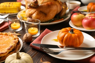 Photo of Traditional Thanksgiving day feast with delicious cooked turkey and other seasonal dishes served on wooden table, closeup