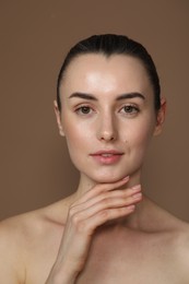 Photo of Portrait of beautiful young woman on light brown background