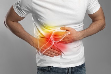 Image of Man suffering from liver pain on grey background, closeup