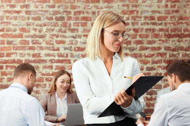 Photo of Businesswoman and her employees in office. Lady boss