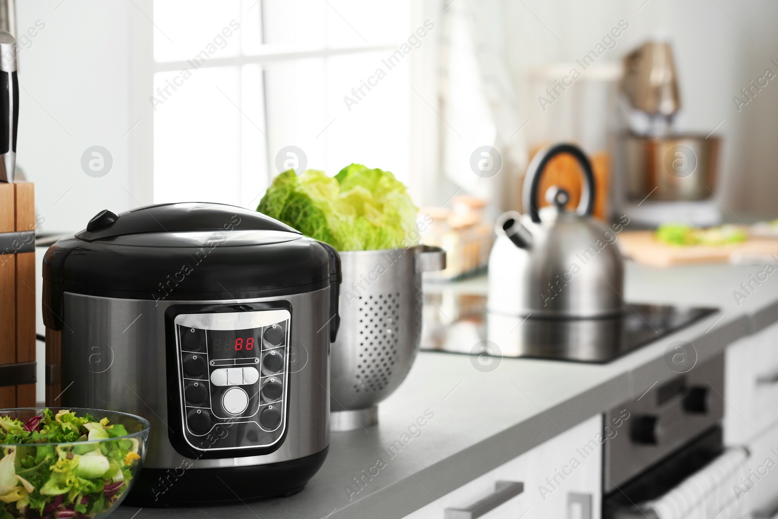 Photo of Modern electric multi cooker and food on kitchen countertop. Space for text