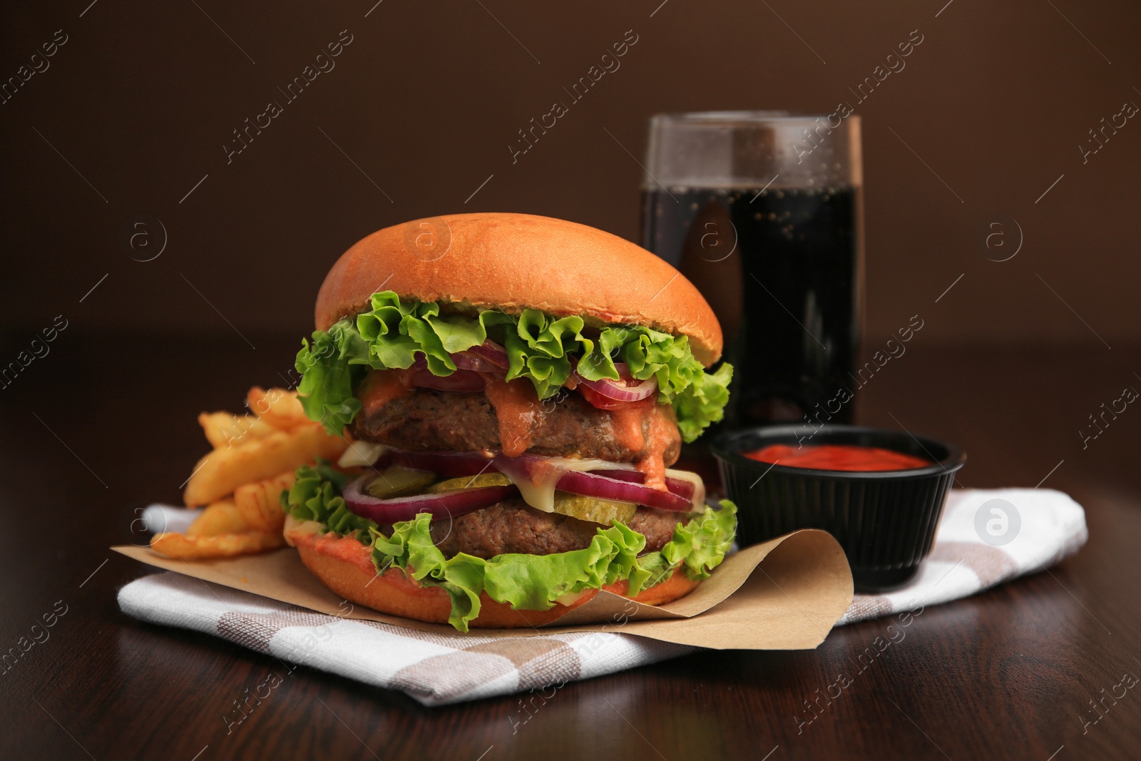 Photo of Tasty burger with vegetables, patties and lettuce served on wooden table