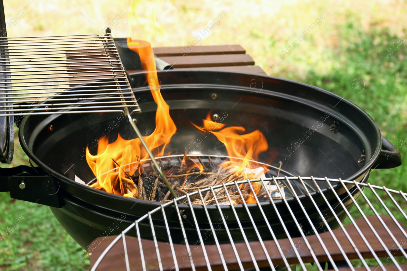 Photo of Modern barbecue grill with fire flames outdoors