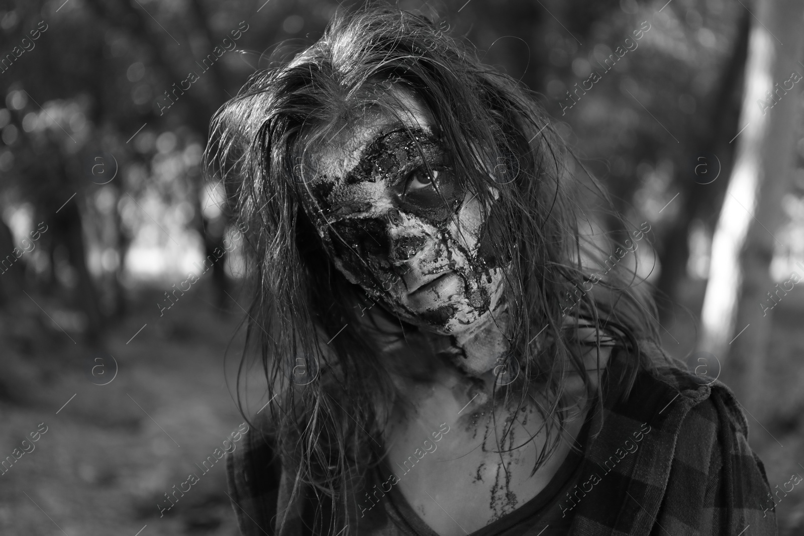 Photo of Scary zombie outdoors, black and white effect. Halloween monster