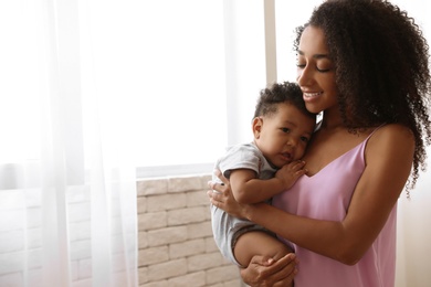 African-American woman with her baby at home. Happiness of motherhood