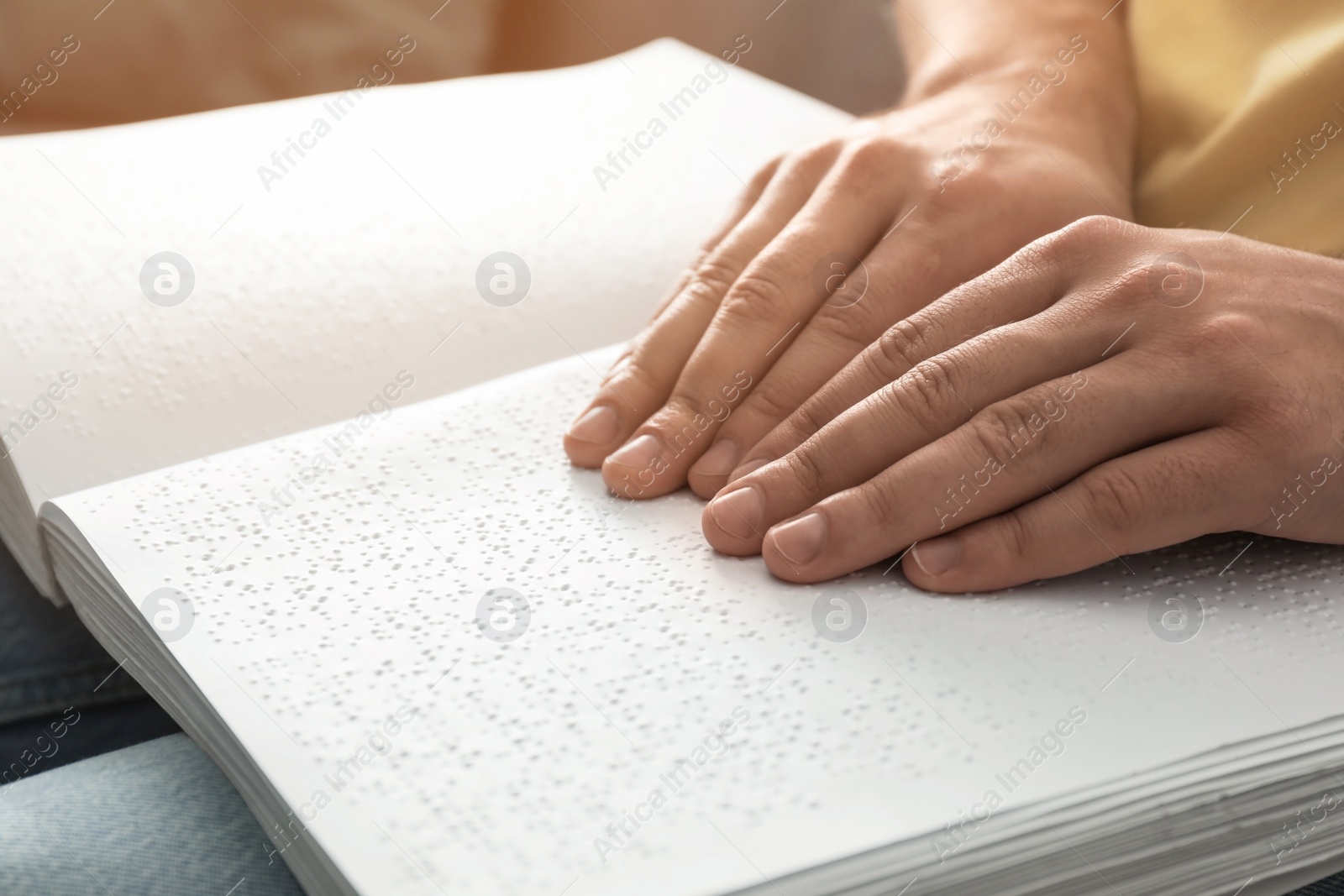 Photo of Blind man reading book written in Braille, closeup