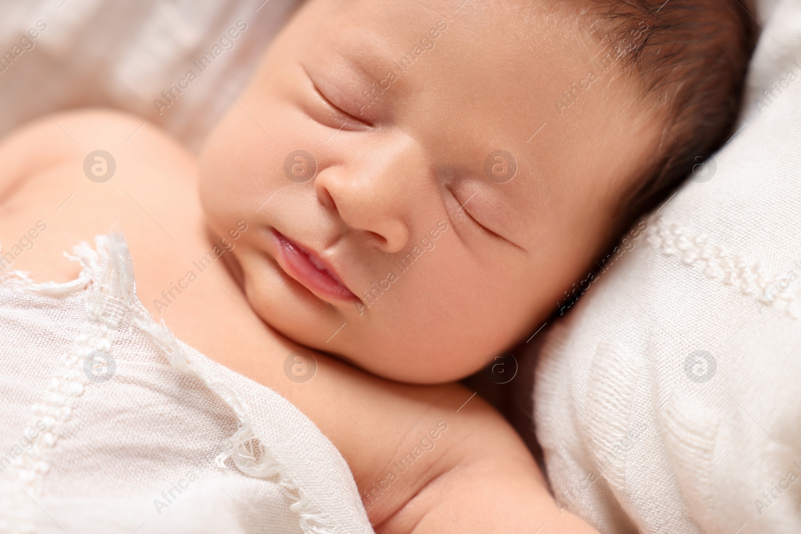 Photo of Cute newborn baby sleeping on white blanket, closeup