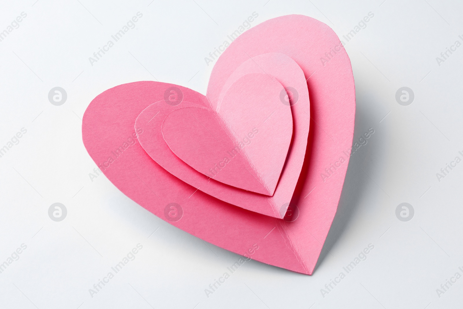 Photo of Pink paper hearts on white background, closeup