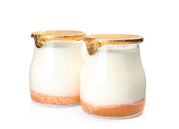 Photo of Glass jars of tasty fruit yogurt on white background