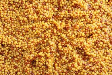 Whole grain mustard as background, top view