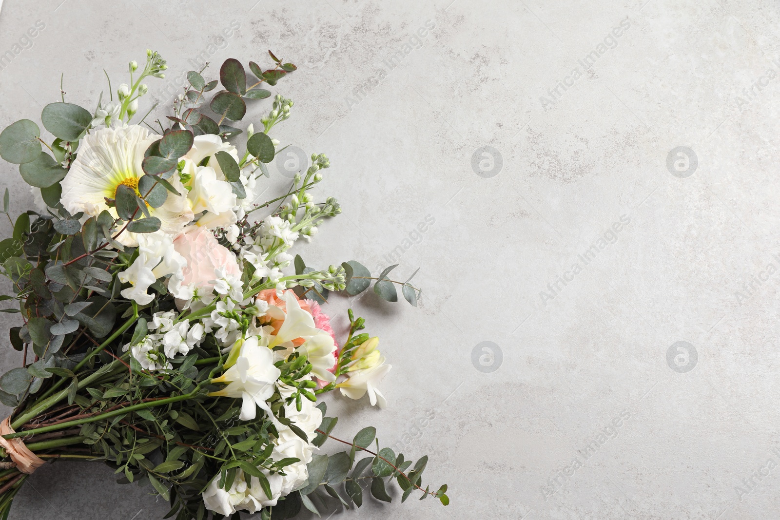 Photo of Bouquet of beautiful flowers on light gray table, top view. Space for text