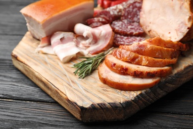 Photo of Cutting board with different sliced meat products served on table