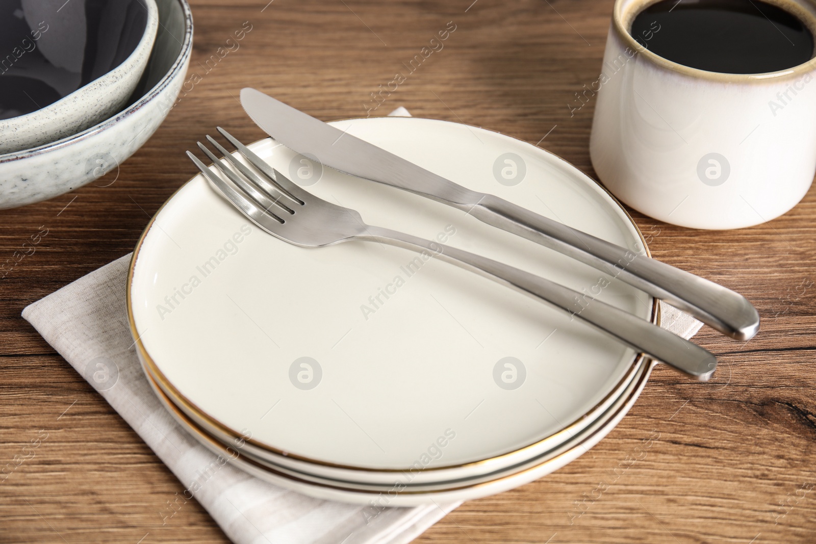 Photo of Set of clean dishware on wooden table