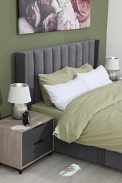 Comfortable bed and bedside tables with lamps in bedroom. Stylish interior design