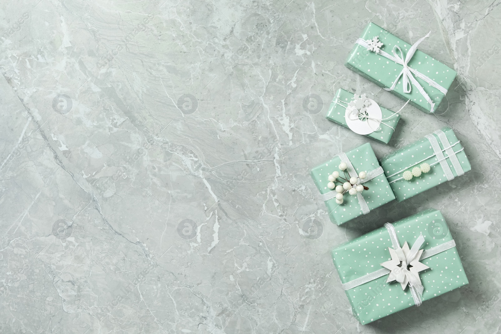 Photo of Christmas gift boxes on light grey marble background, flat lay. Space for text