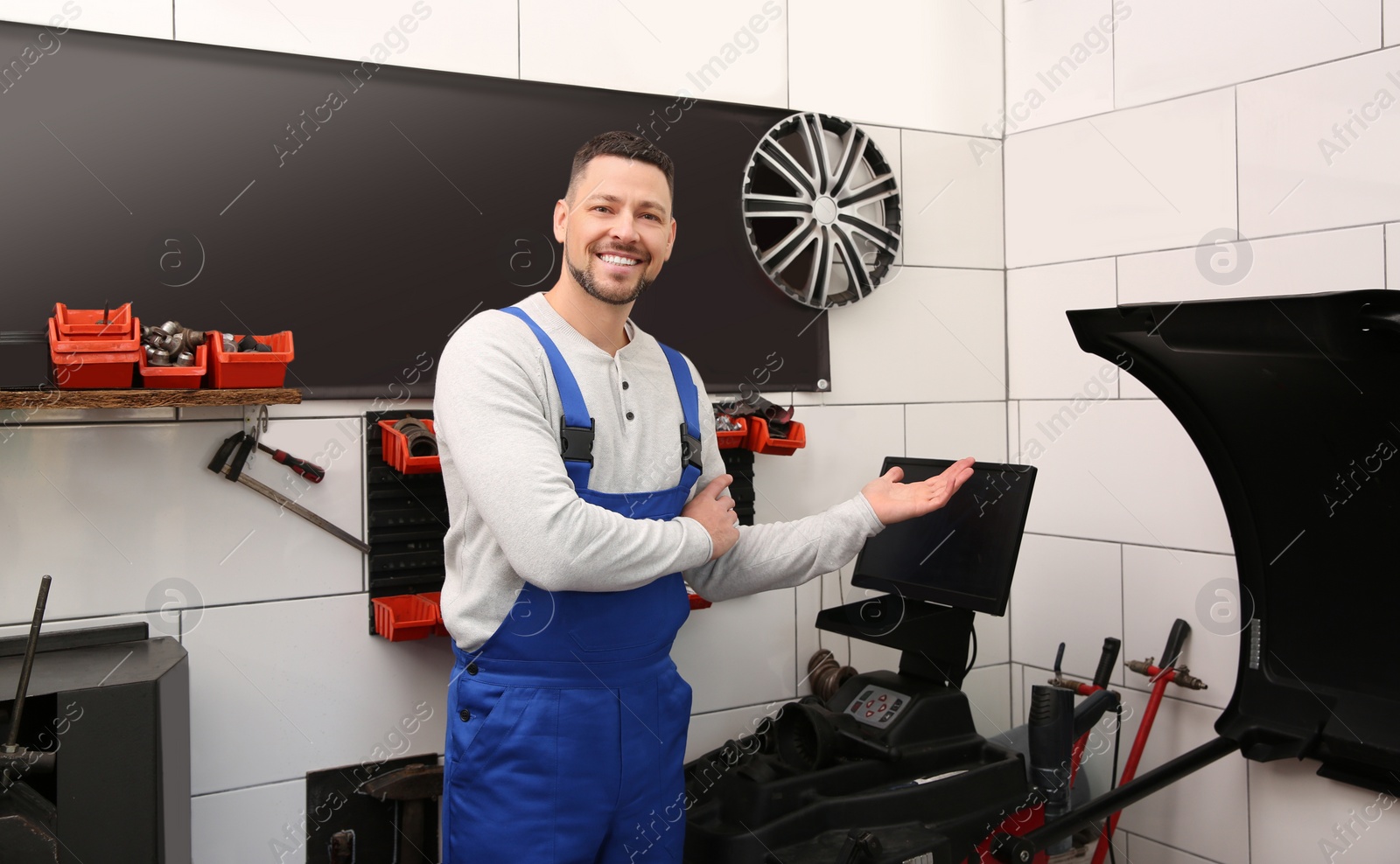 Photo of Mechanic near wheel balancing machine at tire service