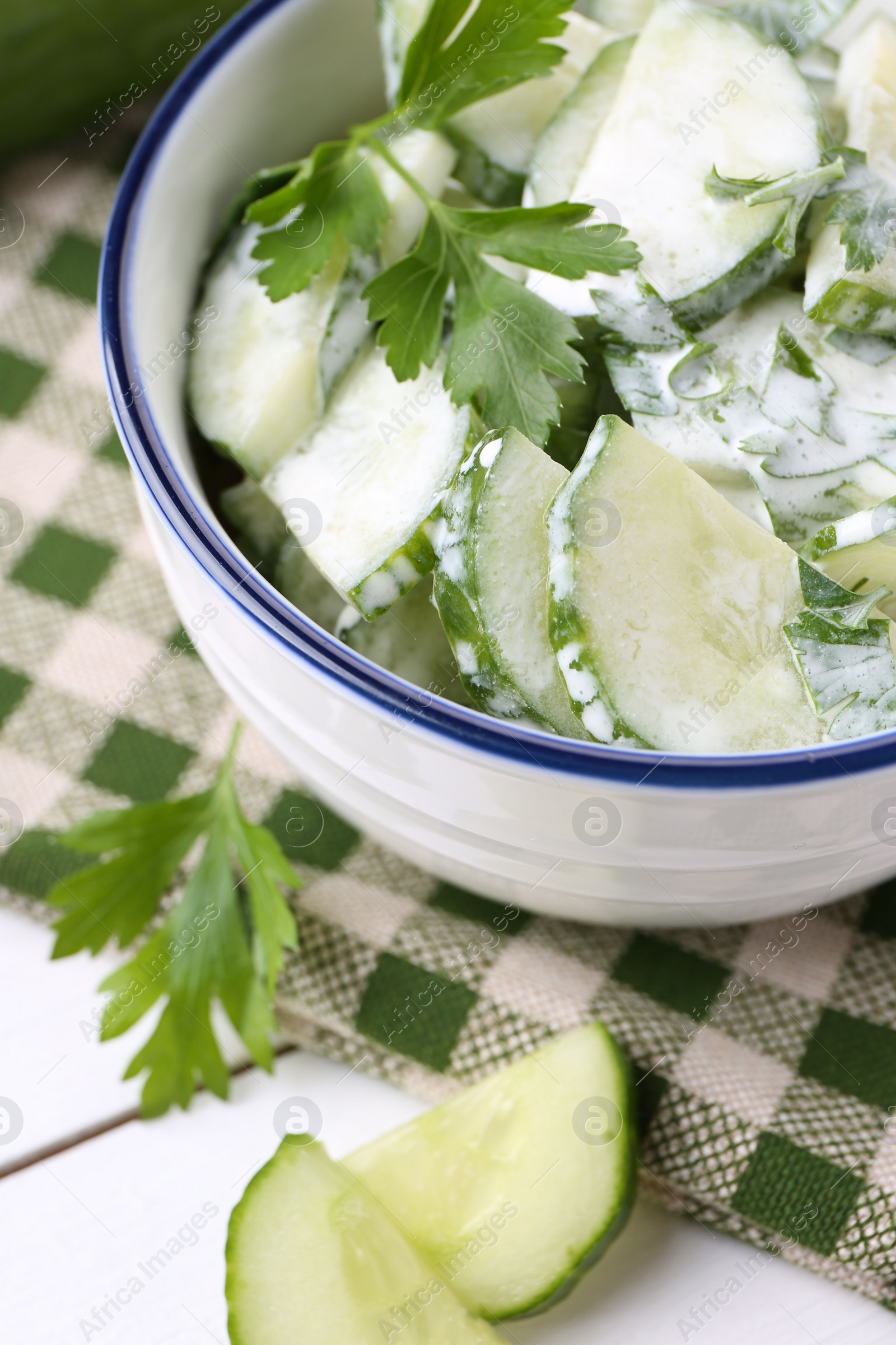 Photo of Delicious cucumber salad in bowl on white table