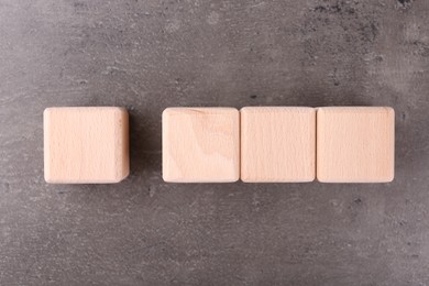 Wooden cubes with check mark and abbreviation ISO on grey textured table, flat lay