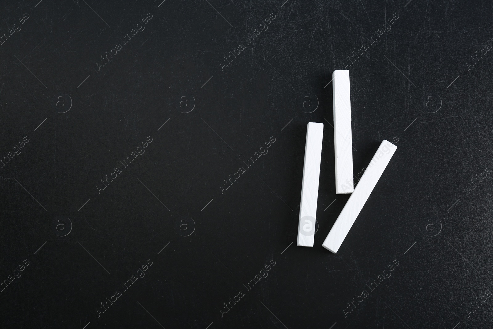 Photo of Pieces of chalk on blackboard, top view