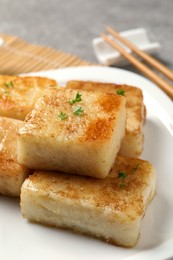 Photo of Ceramic plate with delicious turnip cake on table, closeup