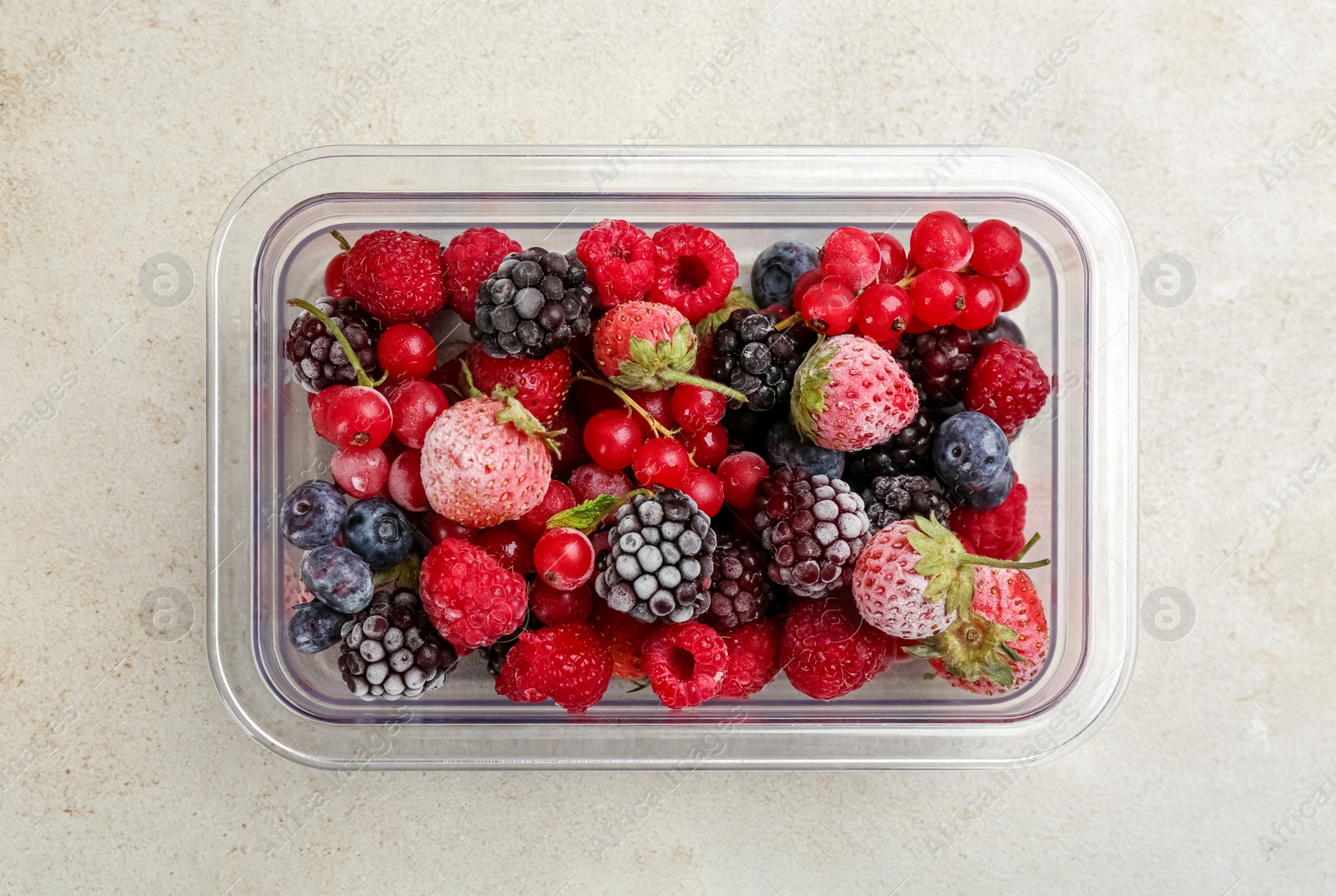 Photo of Mix of different frozen berries on light table, top view