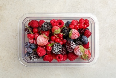 Mix of different frozen berries on light table, top view