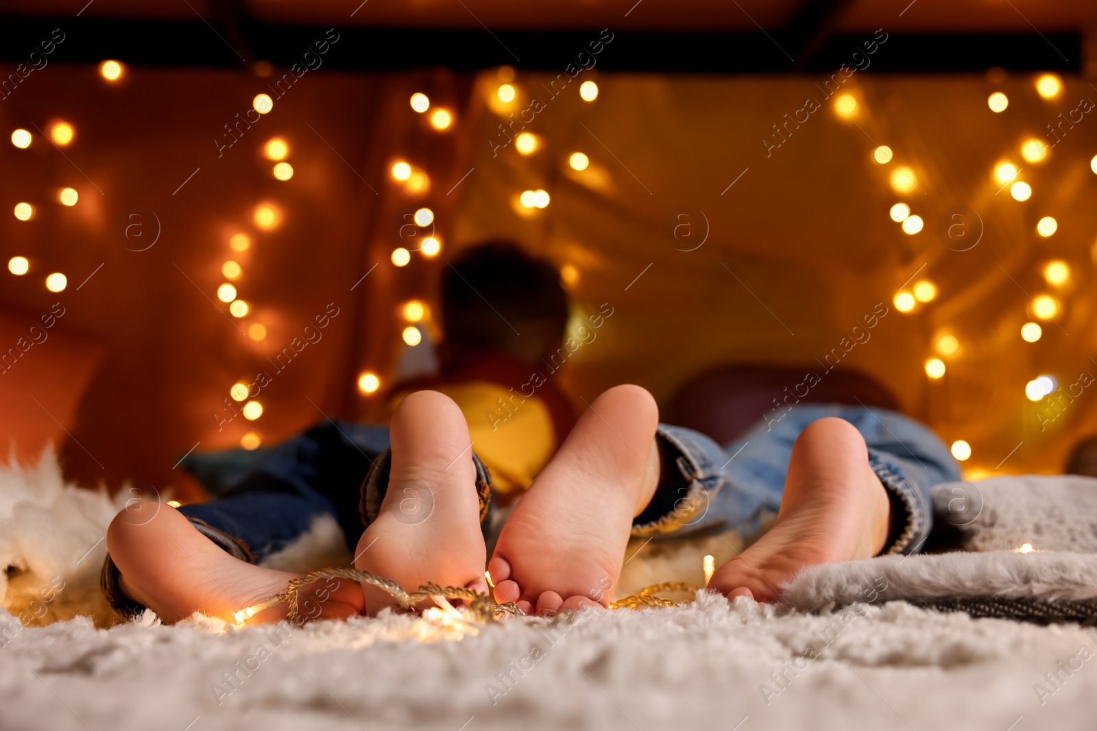 Photo of Kids in decorated play tent at home, focus on feet