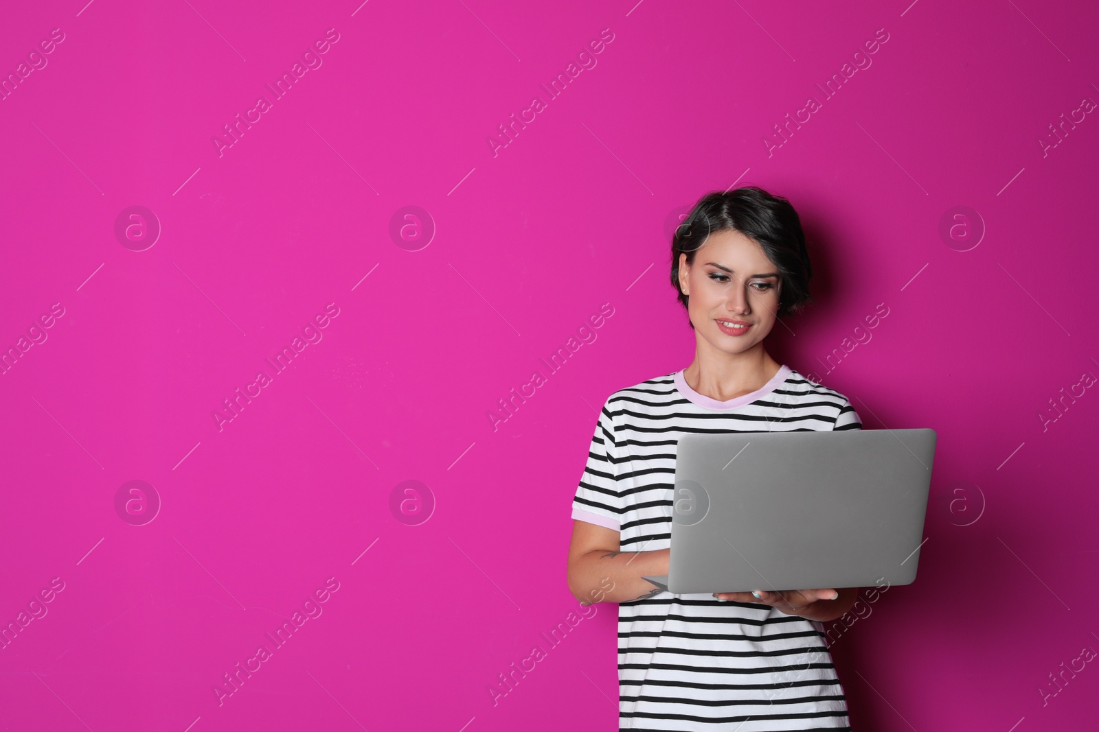 Photo of Young woman with modern laptop on color background