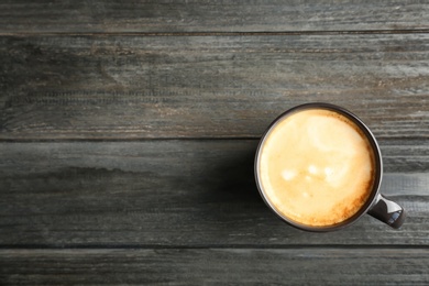 Cup of aromatic hot coffee on wooden background, top view