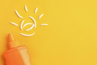 Photo of Drawing of sun and bottle with sunscreen on orange background, top view and space for text. Skin protection