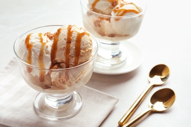 Bowl with caramel ice cream on table